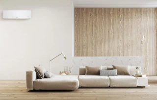 Climatisation murale installée dans un salon moderne pour rafraîchir une maison